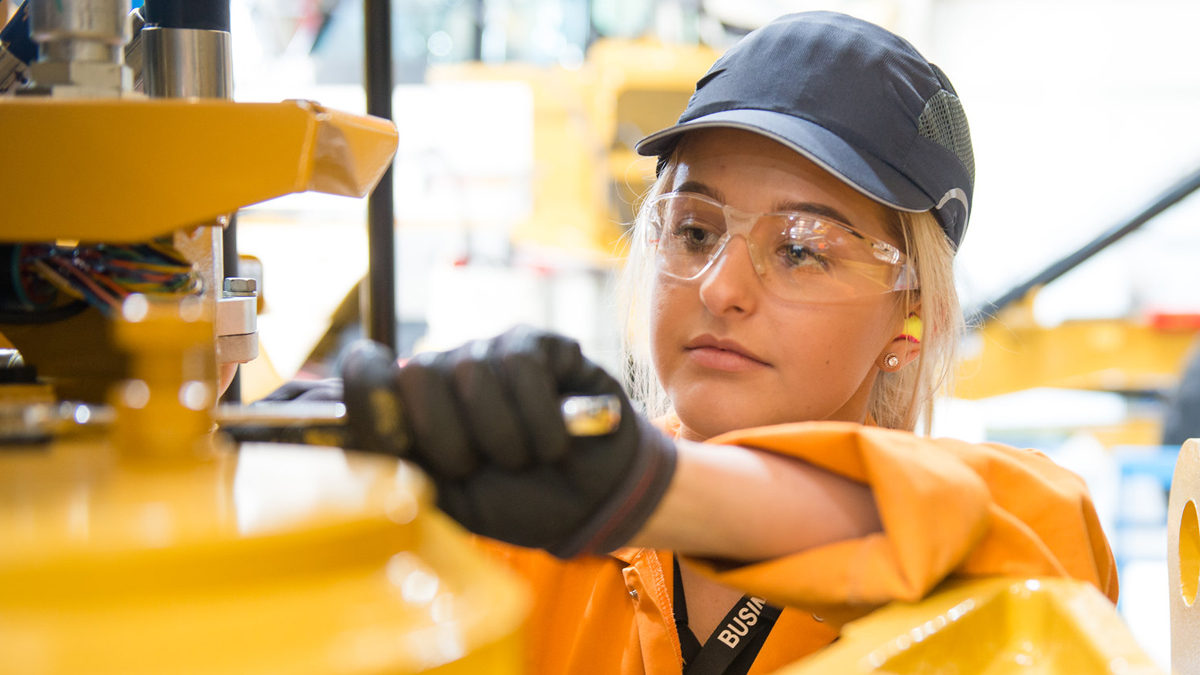 A young female engineering apprentice working on some equipment