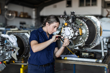 An engineering technician in a workshop working on a piece of machinery