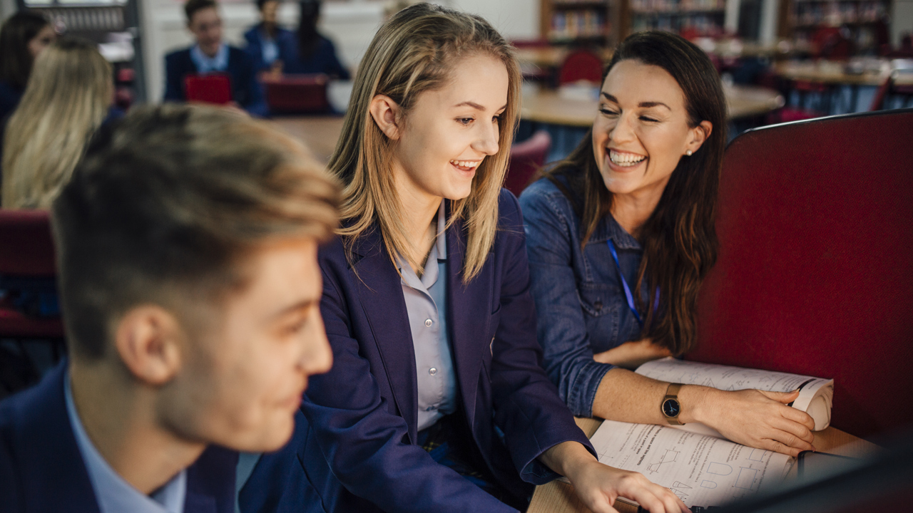 Secondary school girl working with teacher