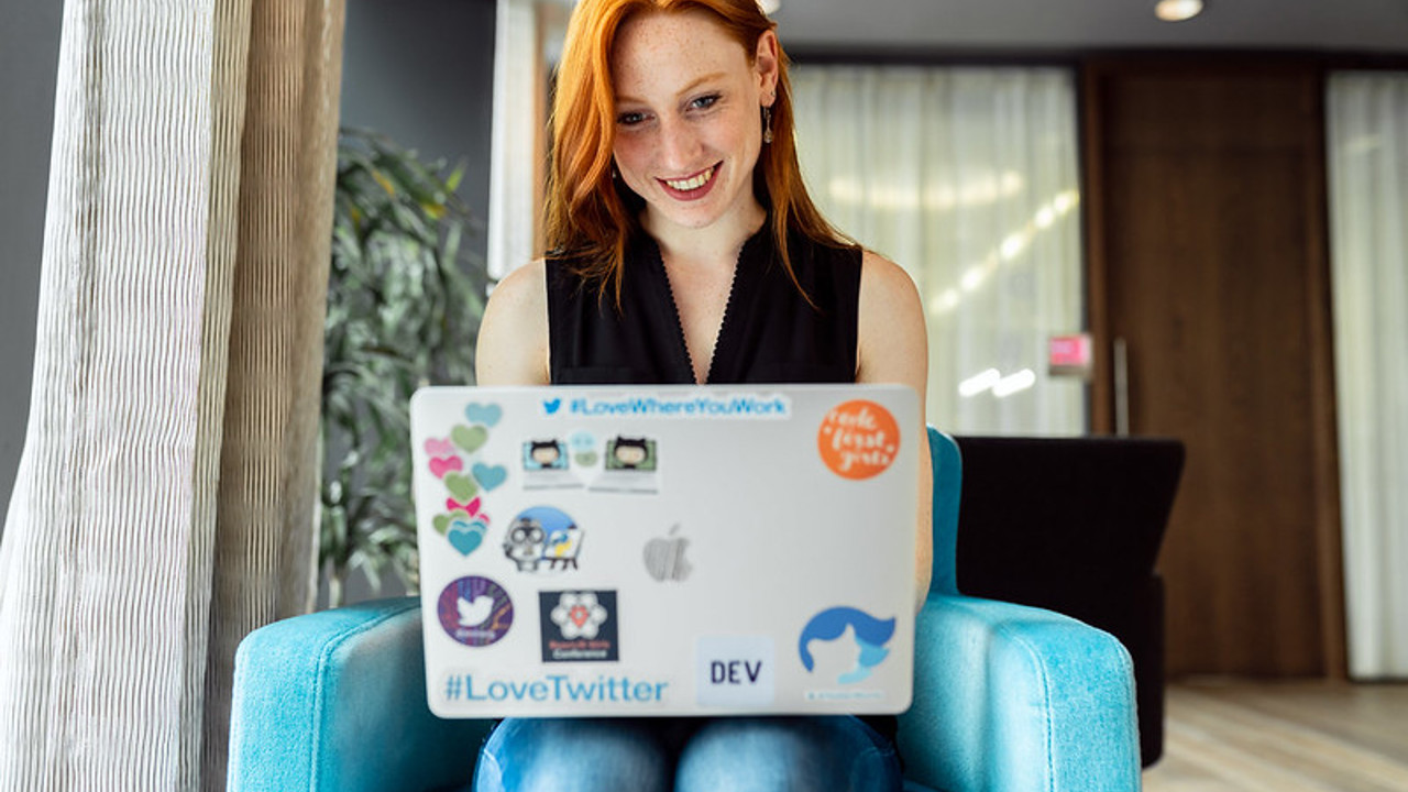 Person sitting on a comfy chair working on their laptop