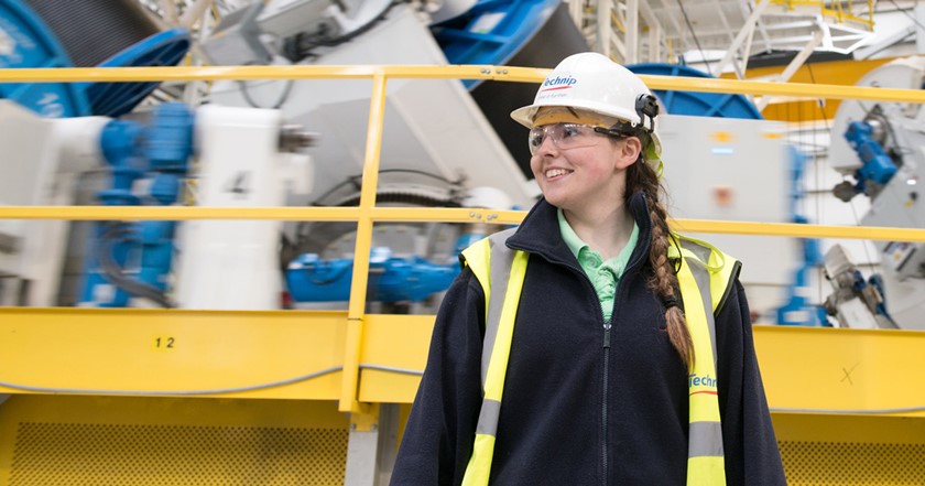 A young female apprentice wearing a hardhat
