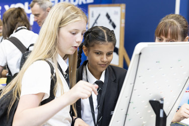 Young people interact with exhibits and stands and activities at The Big Bang Fair