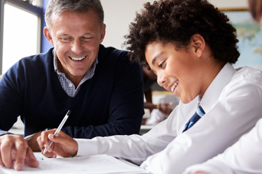 A teacher talks to a young student about his work