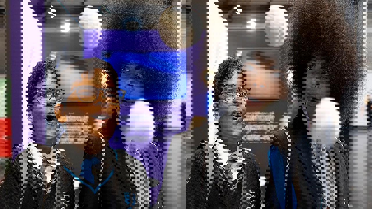 Two young people with expressive faces marvel at a scientific experiment at The Big Bang Fair. In front of them two balls seem to float mid air.