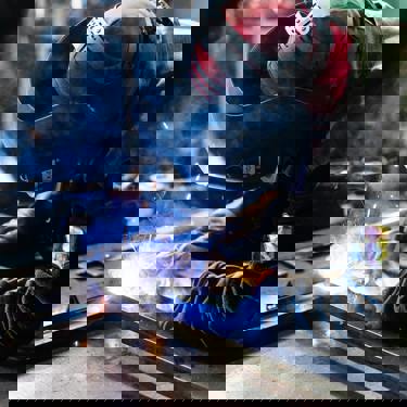 An engineer in protective clothing welding