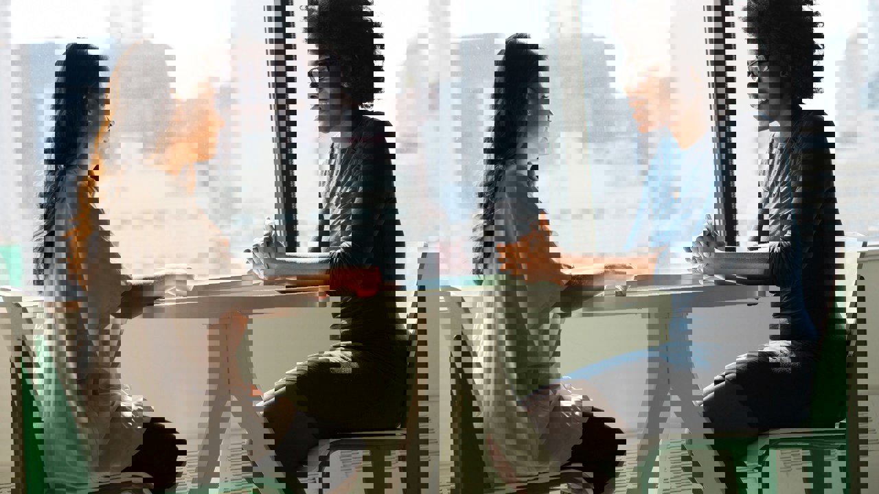 Business professionals talking at a table at their workplace